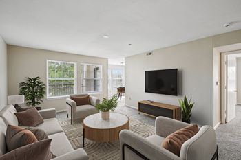 A living room with a flat screen TV and a large window.